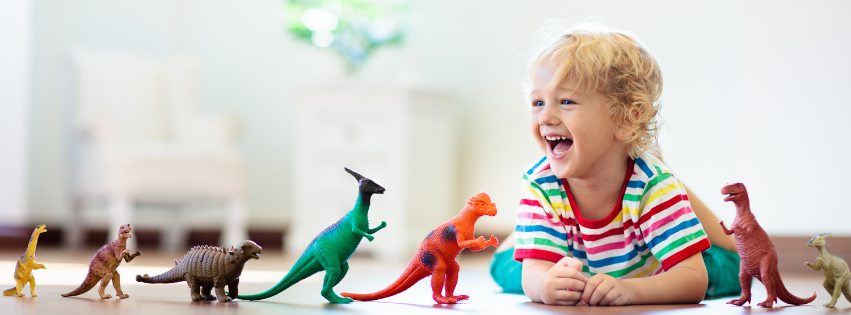 kid playing with toy dinosaurs